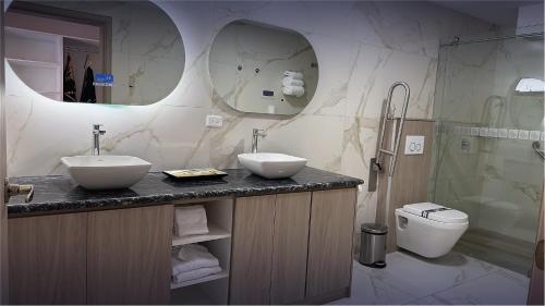 a bathroom with two sinks and a toilet at Hotel Boutique Mitad Del Mundo in Quito