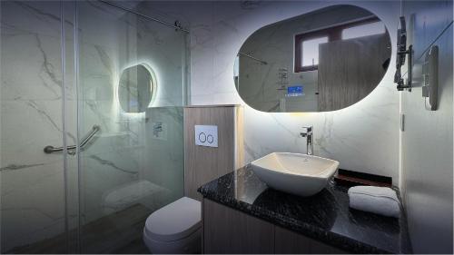 a bathroom with a sink and a toilet and a mirror at Hotel Boutique Mitad Del Mundo in Quito