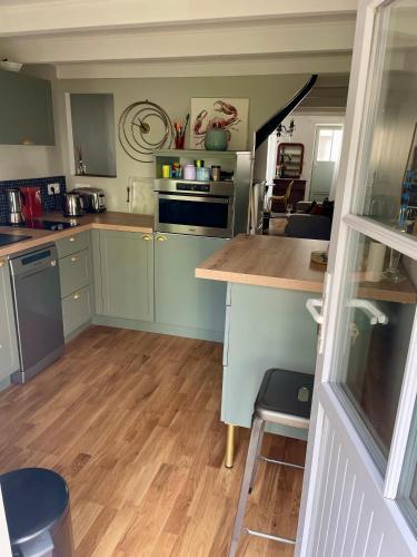 Il comprend une cuisine avec des placards verts et du parquet. dans l'établissement Maison des Alouettes, à Sainte-Marie de Ré