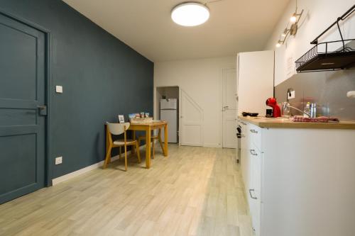 une cuisine avec une table et un mur bleu dans l'établissement Charmant studio, à Reugny