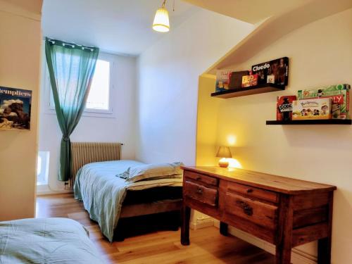 une chambre avec un lit, un bureau et une fenêtre dans l'établissement Appartement 78m - Millau centre - L'échappée belle, à Millau