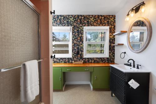 a bathroom with a sink and two windows at Retro Getaway In Hazel Dell in Vancouver
