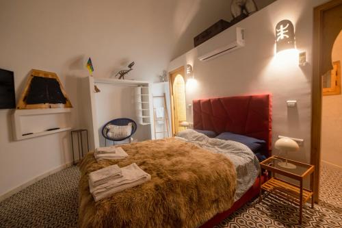 a bedroom with a large bed with a red blanket at Villa Roswell Marrakech in Marrakech