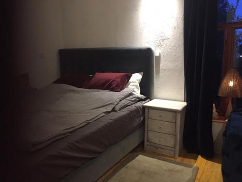 a bedroom with a bed and a night stand with a lamp at Schöne Gartenwohnung im Klosterdorf Mariensee in Neustadt am Rübenberge