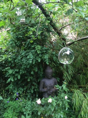 a statue in the middle of a bunch of plants at Schöne Gartenwohnung im Klosterdorf Mariensee in Neustadt am Rübenberge