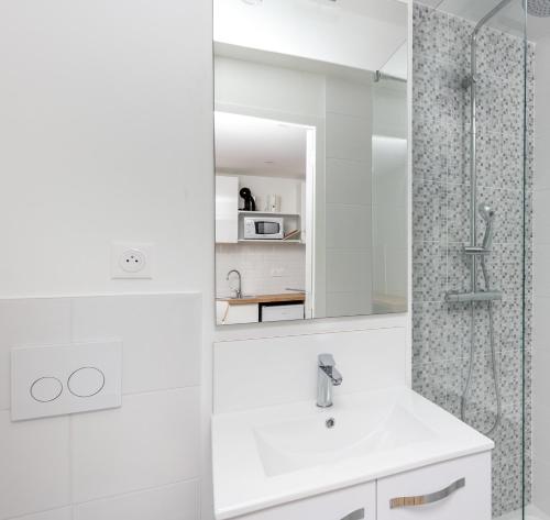 une salle de bain blanche avec un lavabo et une douche dans l'établissement Dame Blanche, à Brest