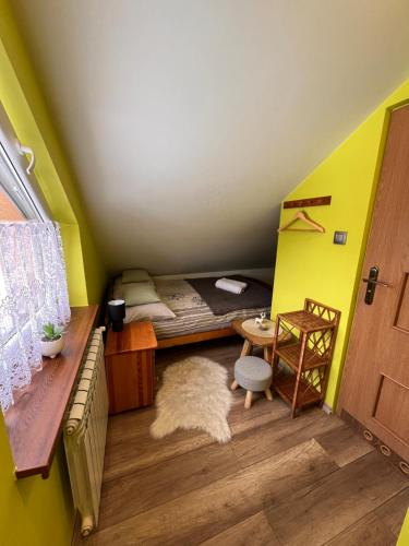 a small room with a bed and a desk and a table at Knieja u Andrzeja in Lutowiska