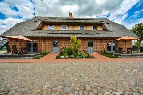 a large brick house with a thatched roof at Dreiurtshof in Remplin