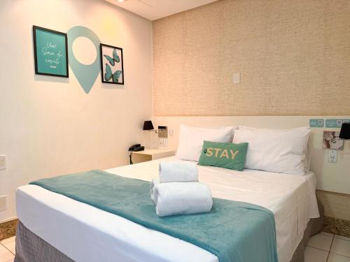 a bedroom with a bed with a green pillow on it at STAY Sun Square in Goiânia