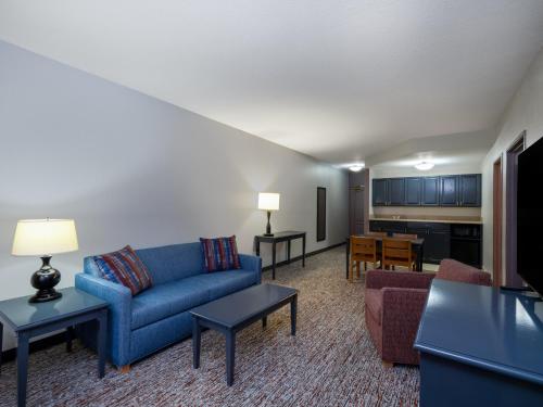 a living room with a blue couch and a table at Garner Hotel Gillette South by IHG in Gillette