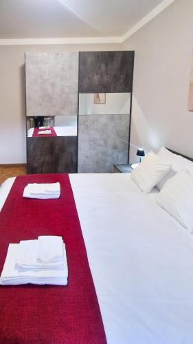 a bedroom with a white bed with a red blanket at Bardonecchia 3-room Apartment - Frejus Palace in Bardonecchia