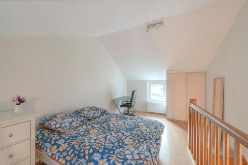 - une chambre avec un lit et un escalier avec une chaise dans l'établissement Duplex hyper center dijon, à Dijon