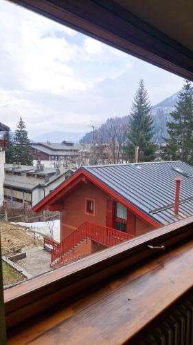 a view of a red house from a window at Bardonecchia 3-room Apartment - Frejus Palace in Bardonecchia