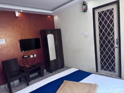 a bedroom with a bed and a tv and a chair at The Fortune inn in Chennai