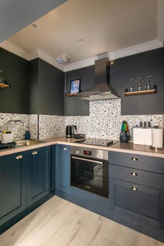 a kitchen with blue cabinets and a stove at Modern 2-bedroom 30 seconds to seafront in Brighton & Hove