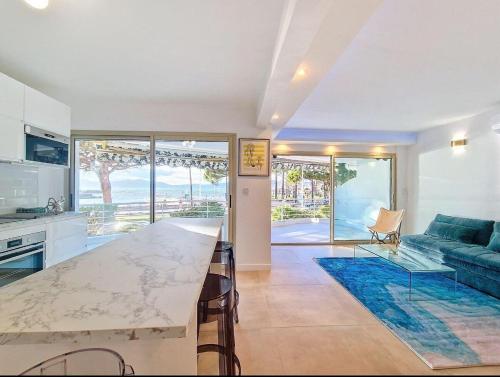 une cuisine et un salon avec une table et un canapé dans l'établissement Le Romance - Palm Beach - Sea View - Wi-Fi - Air Conditioning, à Cannes