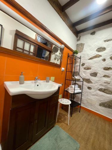 a bathroom with a sink and a rock wall at Casa La Candelaria - Moya in Moya