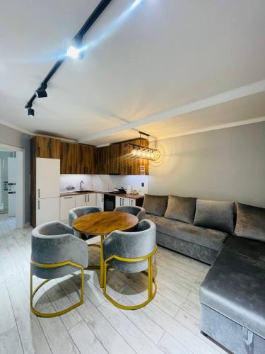 a living room with a table and chairs and a couch at Уютные квартиры в Бишкеке in Bishkek