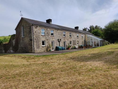 a large brick building with a large yard at The Old Mill, Argideen River Lodges in Timoleague