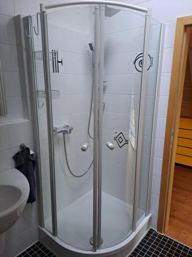 a shower with a glass door in a bathroom at Haus Burg, Ferienhaus in Bongard