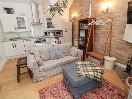 a living room with two couches and a kitchen at The Forge in Chathill