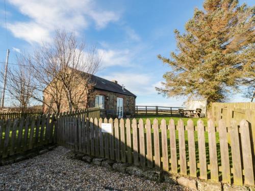 a wooden fence in front of a house at The Forge in Chathill