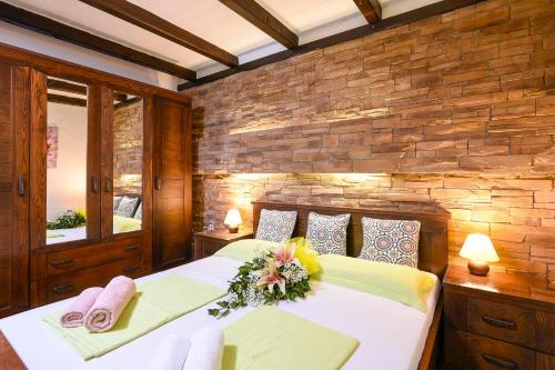a bedroom with two beds and a brick wall at Apartments Vila ViDa Orebić in Orebić