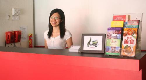 a woman sitting at a counter with a red counter top at Red Inn Court in George Town