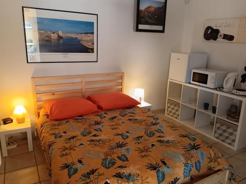 une chambre avec un lit avec des oreillers orange dans l'établissement Chambre privée avec Piscine, à Marseille