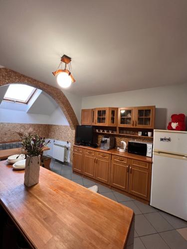 a kitchen with a table and a white refrigerator at Knieja u Andrzeja in Lutowiska