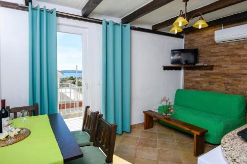a living room with a green couch and a table at Apartments Vila ViDa Orebić in Orebić