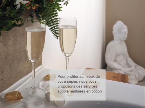 - deux verres de champagne sur une table avec un signe dans l'établissement La Suite Balinaise - Balnéo - Wifi - Netflix - Proche centre ville, à Auxerre
