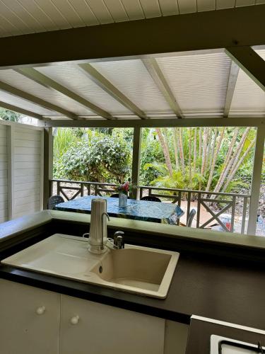 Un fregadero en una cocina con vista a una mesa. en Baz créole, en Deshaies