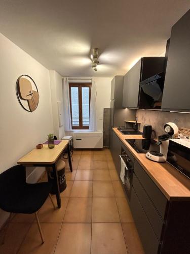 une cuisine avec une table et un comptoir dans l'établissement T2 au cœur de Valbonne Village, à Valbonne