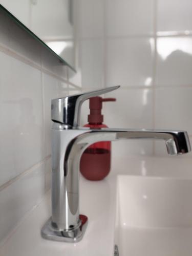 La salle de bains est pourvue d'un lavabo et d'un robinet. dans l'établissement Le gite d'Arsène avec terrasse et garage en option a 200 m de la plage, à Étretat