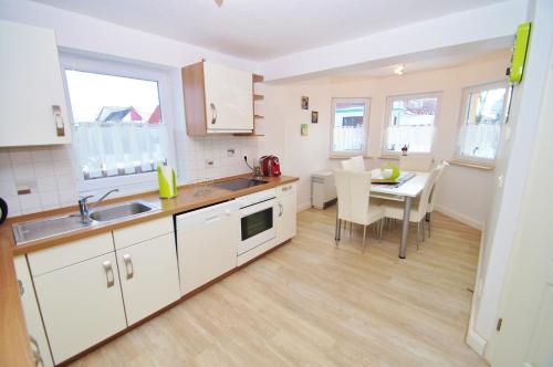 Una cocina con una mesa y un comedor. en Ferienhaus Timm, en Kellenhusen
