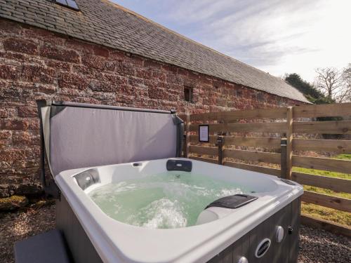 a bath tub sitting next to a brick building at Milltown House in Turriff