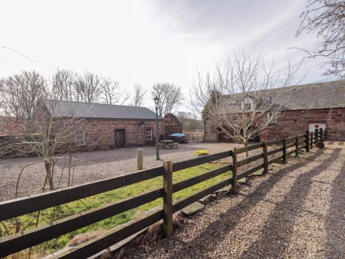a wooden fence in front of a barn at Milltown House in Turriff