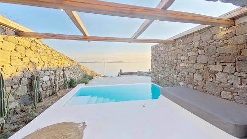 a stone walled house with a swimming pool at Ria Mar Villas & Suites by Live&Travel in Houlakia