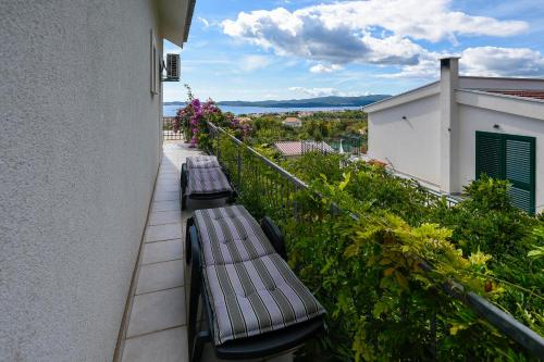 two benches sitting on the balcony of a building at Apartments Vila ViDa Orebić in Orebić