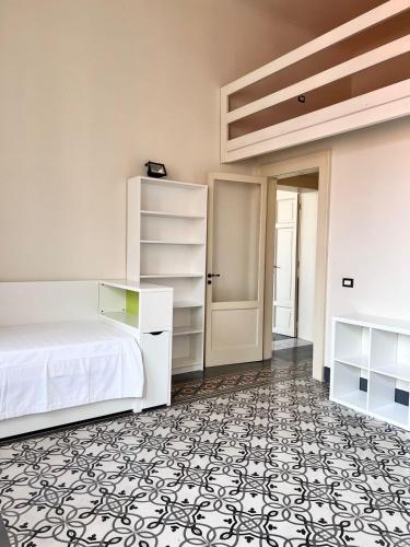 - une chambre avec un lit blanc et un sol noir et blanc dans l'établissement Best Stay-Theatre Suite Apartment, à Bari