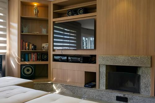 a living room with a fireplace and a tv at Conforto e Espaço para Família, 2 vagas, WiFi 500m in Curitiba