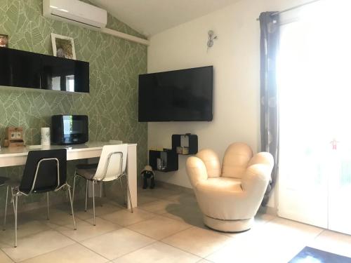 a living room with a desk and a white chair at soleil d'or in Argelès-sur-Mer