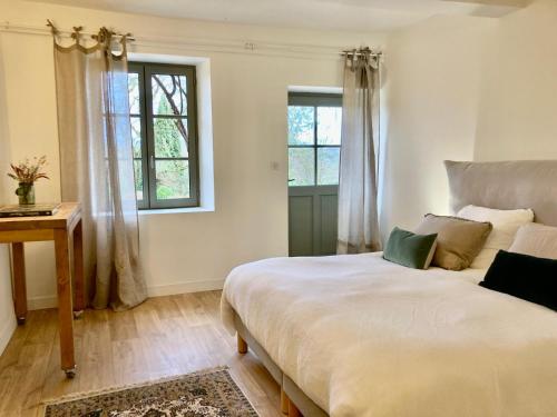 una camera da letto con un letto grande e una finestra di Le Jardin de Marie - la maison d'hôtes Sancerre a Neuilly-en-Sancerre