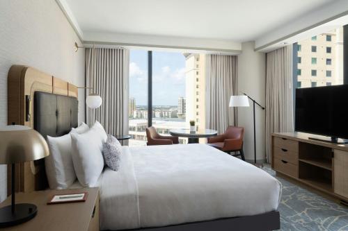 a hotel room with a bed and a flat screen tv at JW Marriott Tampa Water Street in Tampa