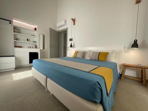 a bedroom with a large bed and a kitchen at Dimora Ferralasco in Carloforte