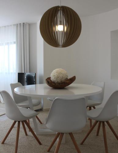 a white dining room with a white table and chairs at Apartamento Morning Cascade in Carvoeiro