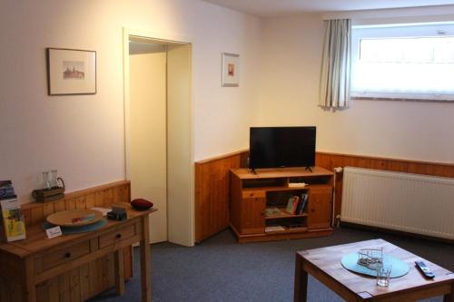 a living room with a tv and a table at Ferienwohnung Struve Nr 2 in Petersdorf auf Fehmarn