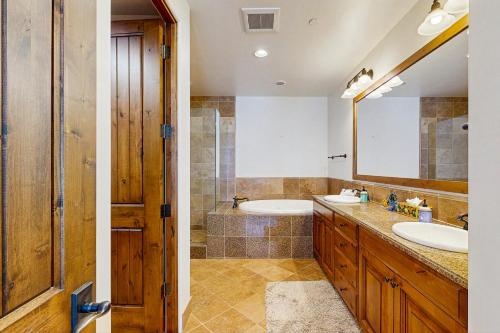 Un baño con bañera, lavabo y espejo. en Luxury Mountain Townhome, en Ketchum