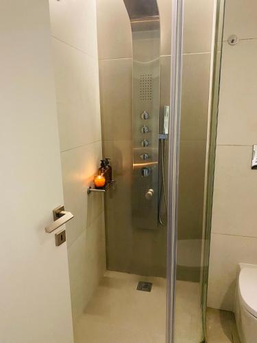 a shower with a glass door in a bathroom at New Modern 2BD aprt with shared rooftop pool B2 in Athens